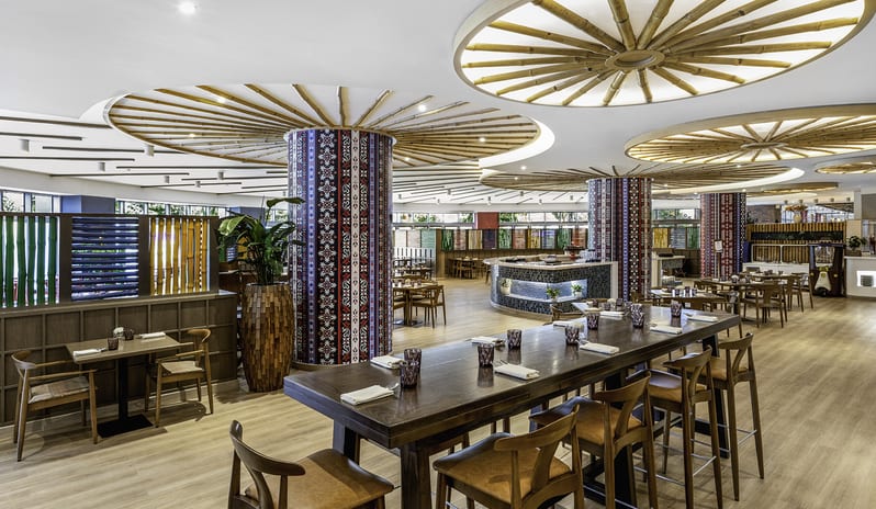 Suan Bua sContemporary restaurant dining room with unique bamboo spoke ceiling design, patterned support columns, and wooden furniture at Centara Mirage Beach Resort Dubai by Kenwood Travel