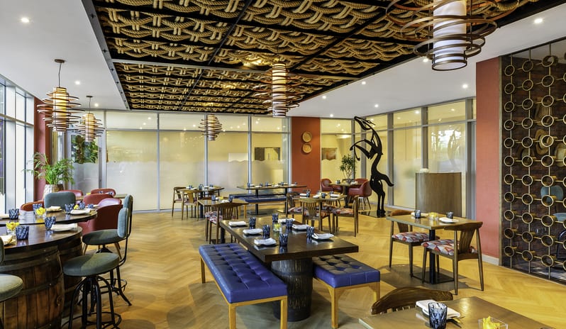 Uno Mas Brightly lit restaurant dining room at Uno Mas showing a mix of wooden tables, colorful chairs, and distinctive Mexican-inspired architectural details at Centara Mirage Beach Resort Dubai by Kenwood Travel