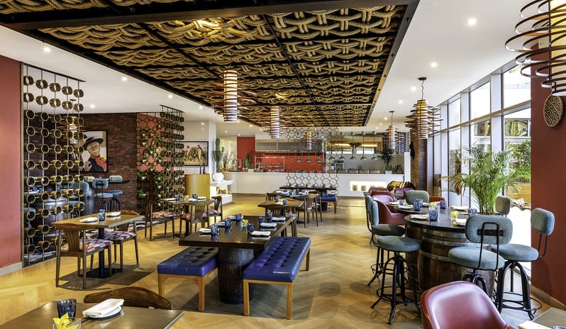 Uno Mas intricate woven rope ceiling, herringbone wood floors, rustic wine barrel tables with teal barstools, and modern Mexican-inspired decor at Centara Mirage Beach Resort Dubai by Kenwood Travel