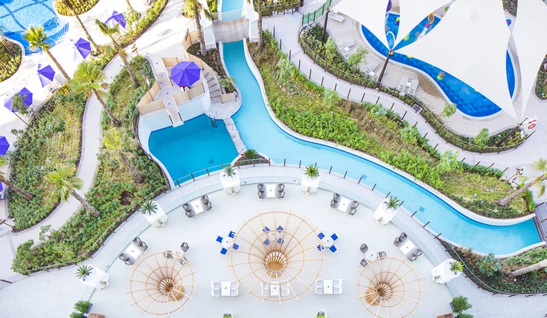 Vistas Lobby Bar lazy river water feature, a children's splash pool with white sails, and an outdoor patio lounge at Centara Mirage Beach Resort Dubai by Kenwood Travel