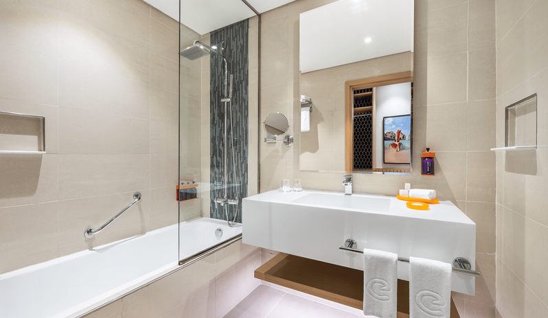 Mirage Family Room Panoramic Sea View with Bunk Beds bathroom highlighting a glass-enclosed bathtub shower combo and a sleek white washbasin vanity at Centara Mirage Beach Resort Dubai by Kenwood Travel