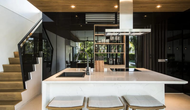 Signature Two Bedroom Deluxe Pool Villa villa kitchen design with a marble breakfast bar island, minimalist wooden ceiling panels, stainless steel range hood, and sleek black cabinetry at Sailing Club Signature Resort Phu Quoc Hotel by Kenwood Travel