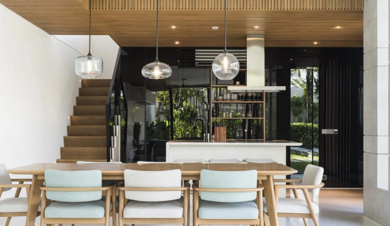 Signature Two Bedroom Deluxe Pool Villa villa kitchen design with a marble breakfast bar island, minimalist wooden ceiling panels, stainless steel range hood, and sleek black cabinetry at Sailing Club Signature Resort Phu Quoc Hotel by Kenwood Travel