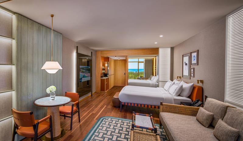 Superior Room king bed, hardwood floors, a small sitting area, and a private balcony view at Gloria Serenity Resort by Kenwood Travel