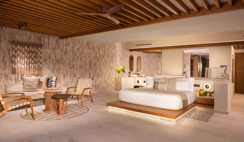 Honeymoon Suite Ocean View bedroom with wooden slatted ceiling and modern boho furniture at Impression Isla Mujeres by Secrets by Kenwood Travel