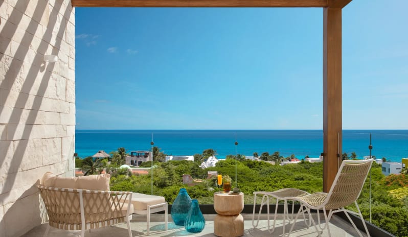 Junior Suite King Partial Ocean View private terrace with premium patio furniture and a tropical ocean view at Impression Isla Mujeres by Secrets by Kenwood Travel