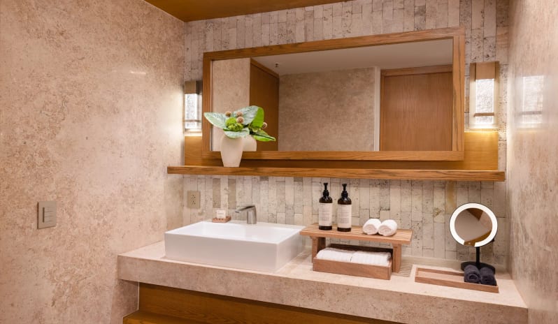 Junior Suite Double Partial Ocean View bathroom with stone vanity counter and large wooden mirror at Impression Isla Mujeres by Secrets by Kenwood Travel