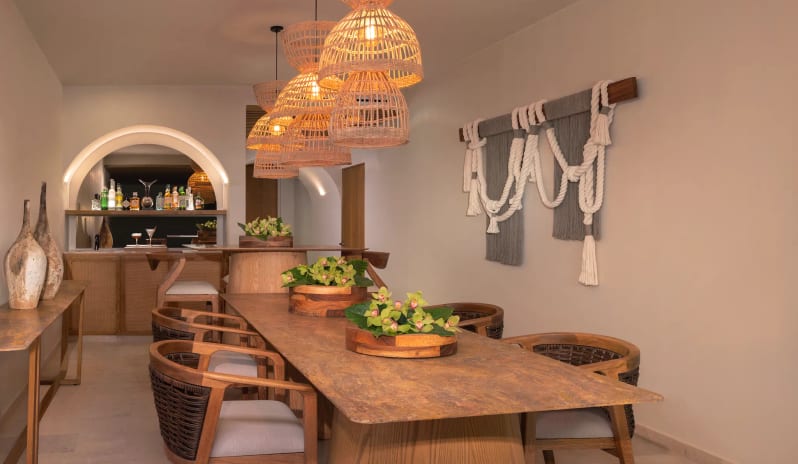 Presidential Suite king suite dining room with textured table, woven chairs, and bohemian lighting at Impression Isla Mujeres by Secrets by Kenwood Travel