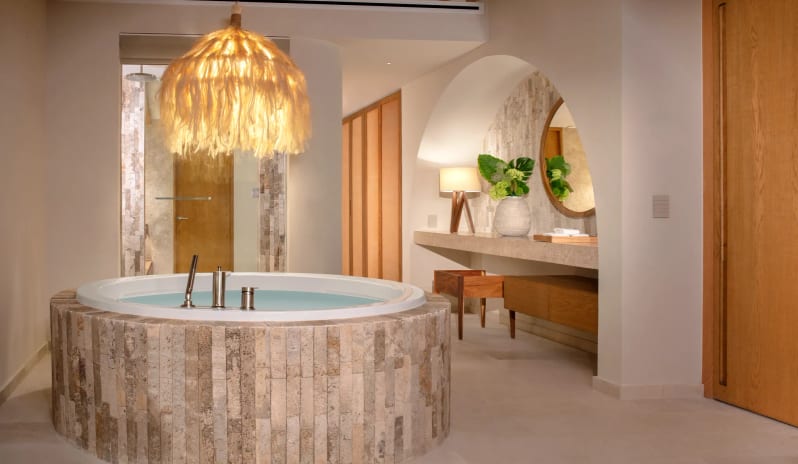 Presidential Suite bathroom with round stone jacuzzi and lighted vanity alcove at Impression Isla Mujeres by Secrets by Kenwood Travel
