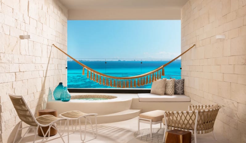 Signature Junior Suite Double Ocean Front W/ Hot Tub balcony with private hot tub, lounge chairs, and a tasseled hammock at Impression Isla Mujeres by Secrets by Kenwood Travel