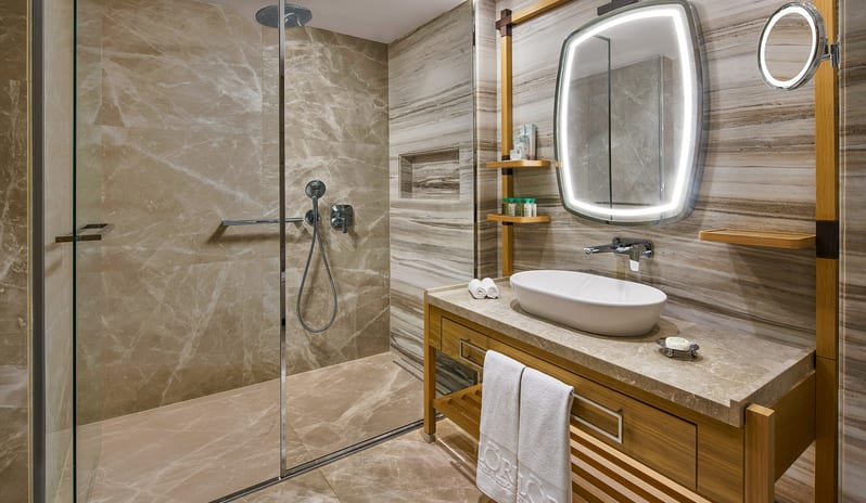 Superior Sea View Room en-suite bathroom with marble tile finishes and an illuminated vanity mirror at Gloria Serenity Resort by Kenwood Travel