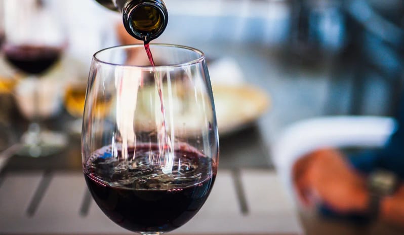 Unik the Kitchen Red wine pouring into a wine glass during dinner service at a luxury resort at Impression Isla Mujeres by Secrets by Kenwood Travel