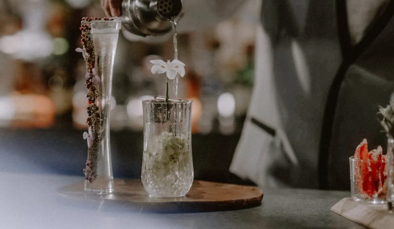 Spezia mixologist preparing a signature craft cocktail at an upscale resort lounge at Impression Isla Mujeres by Secrets by Kenwood Travel