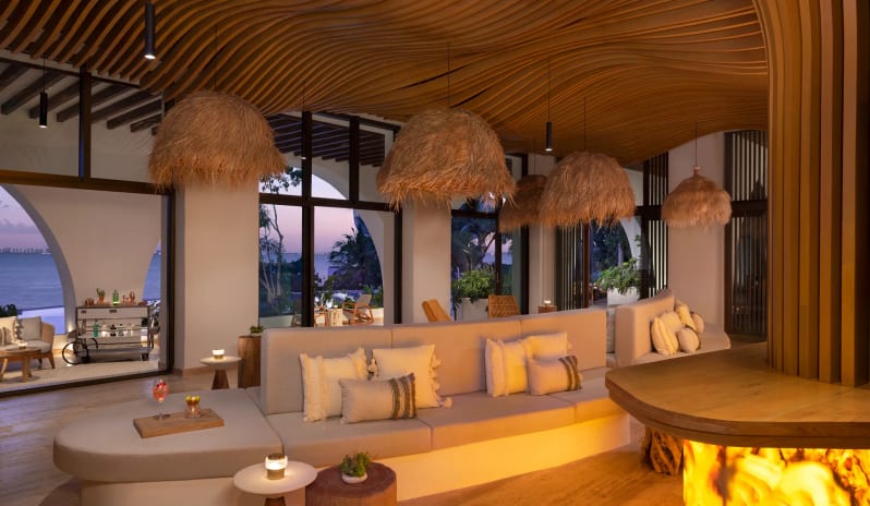 Isola lobby lounge with dramatic architectural wood features, straw pendant lamps, and scenic ocean views at Impression Isla Mujeres by Secrets by Kenwood Travel