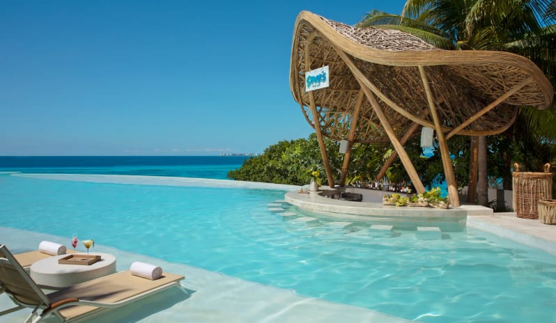 Sharks swim-up pool bar with a distinctive bamboo canopy and stunning ocean views at Impression Isla Mujeres by Secrets by Kenwood Travel