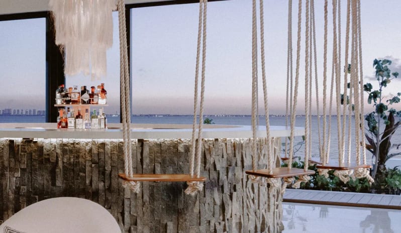 Unik the Kitchen rooftop bar with indoor swing seating and panoramic ocean views at Impression Isla Mujeres by Secrets by Kenwood Travel