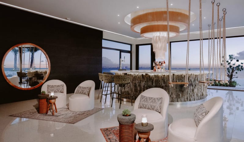 The Top rooftop bar and lounge with indoor swing chairs, elegant seating, and panoramic ocean views at Impression Isla Mujeres by Secrets by Kenwood Travel