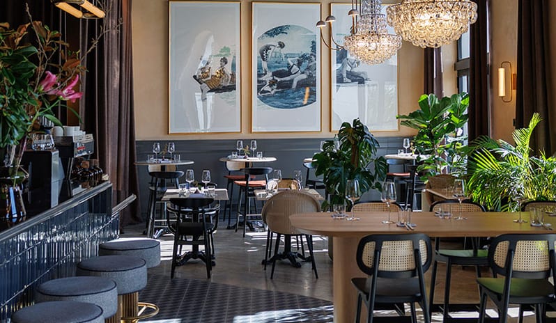 JAZ by Ana Roš Elegant dining room and bar counter with crystal chandeliers, wall art, and woven chairs at Pical Resort, Valamar Collection by Kenwood Travel