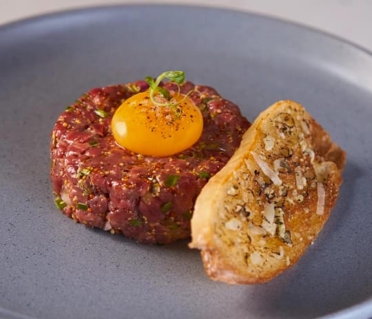 JC Steakhouse Grilled Fresh beef tartare appetizer served with toasted bread at Moon Palace The Grand Punta Cana by Kenwood Travel