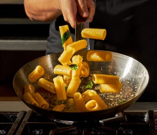 The Grand Buffet Chef tossing fresh pasta in a skillet at Moon Palace The Grand Punta Cana by Kenwood Travel