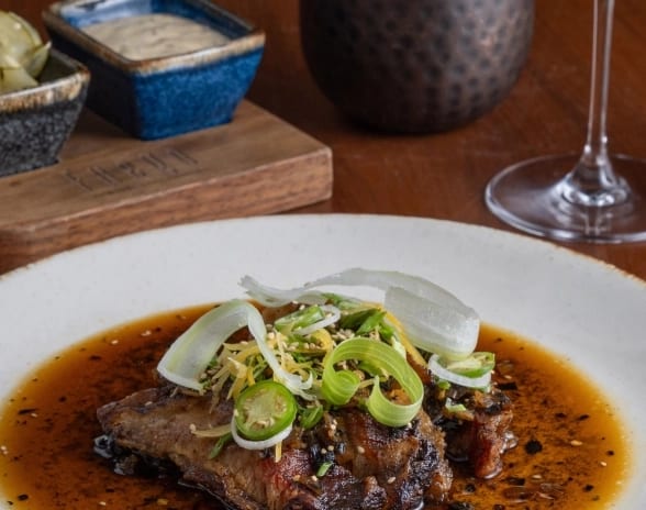 Fuego Gourmet meat dish served with rich sauce and red wine at Moon Palace The Grand Punta Cana by Kenwood Travel