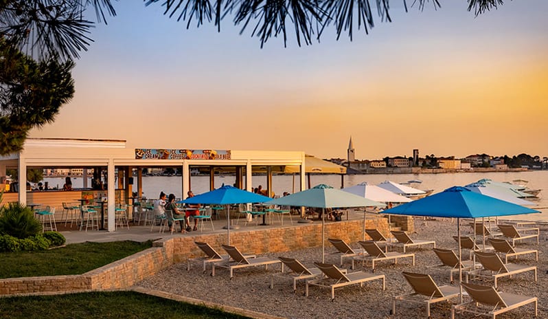 Barka Beach Bar Beachfront bar terrace and sun loungers at sunset at Pical Resort, Valamar Collection by Kenwood Travel