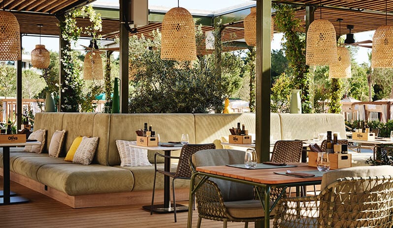 Oliva Grill Outdoor dining terrace with woven lamps and green banquette seating at Pical Resort, Valamar Collection by Kenwood Travel