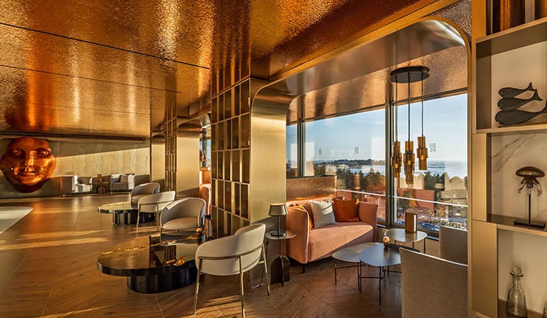 Pical rooftop bar by Laurent Perrier shimmering copper ceiling tiles, elegant armchairs, decorative wall sculptures, and panoramic ocean views at Pical Resort, Valamar Collection by Kenwood Travel