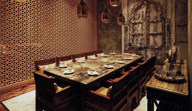 Agra legant private dining setup with traditional wooden jaali lattice and warm ambient pendant lights at Moon Palace The Grand Punta Cana by Kenwood Travel