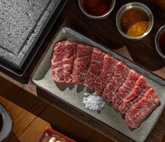 Jade Premium marbled beef slices served with dipping sauces and a hot stone grill plate at Moon Palace The Grand Punta Cana by Kenwood Travel