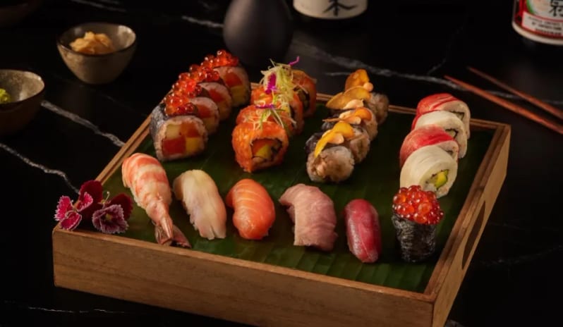 Jade Gourmet Japanese sushi platter with nigiri and specialty rolls on a wooden tray at Moon Palace The Grand Punta Cana by Kenwood Travel