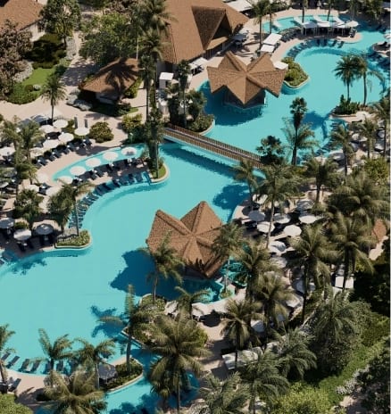 Jungle Pool Bar High-angle aerial view of a tropical resort swimming pool complex with palm trees at Moon Palace The Grand Punta Cana by Kenwood Travel