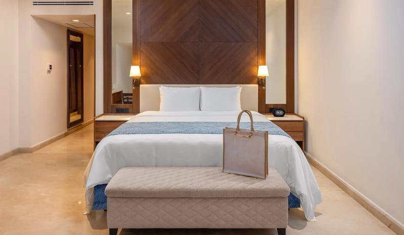 Grand Junior Suite Golf View King bed with decorative wood headboard at Moon Palace The Grand Punta Cana by Kenwood Travel