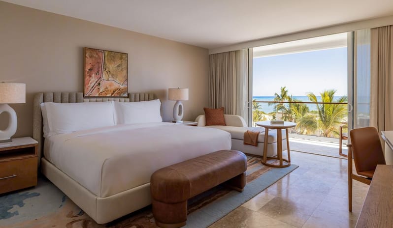 Deluxe Ocean View King Bed, Balcony oceanview guest bedroom with king bed and private balcony overlooking palm trees at Salterra, A Luxury Collection Resort & Spa, South Caicos by Kenwood Travel
