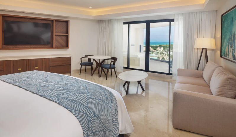 Grand Presidential Suite Ocean View king bed, modern living space, and private balcony overlooking the resort and sea at Moon Palace The Grand Punta Cana by Kenwood Travel