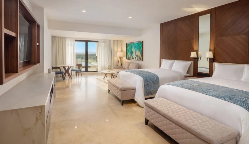 Grand Superior Deluxe Golf View two double beds, modern wood paneling, and private balcony seating at Moon Palace The Grand Punta Cana by Kenwood Travel