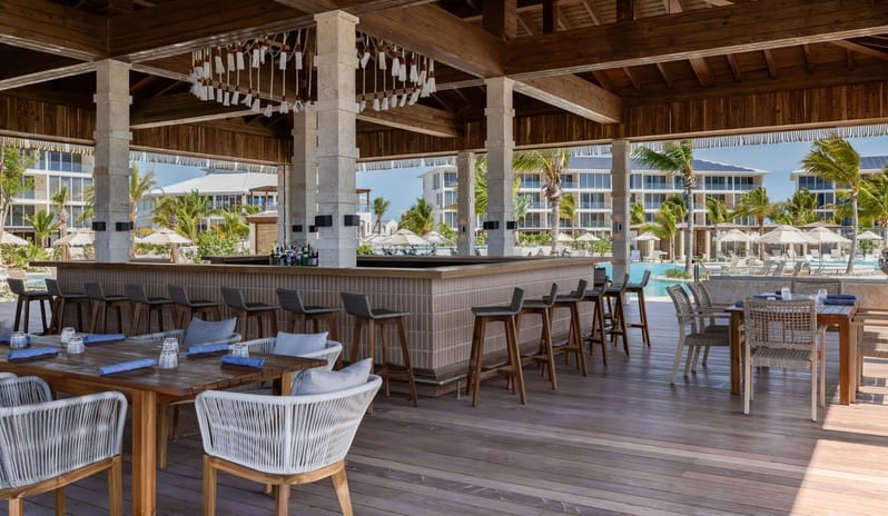 Cobo Bar & Grill Covered outdoor resort bar and dining patio with high bar stools and pool views at Salterra, A Luxury Collection Resort & Spa, South Caicos by Kenwood Travel