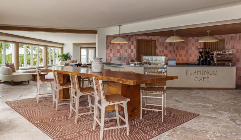 Flamingo Cafe ordering counter with pink backsplash tile and a large wooden communal table at Salterra, A Luxury Collection Resort & Spa, South Caicos by Kenwood Travel