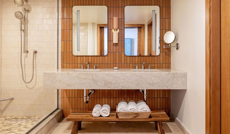 Two Bedroom Ocean View Suite Balcony bathroom featuring a floating marble double vanity, terra-cotta tile wall, backlit mirrors, and a walk-in shower at Salterra, A Luxury Collection Resort & Spa, South Caicos by Kenwood Travel