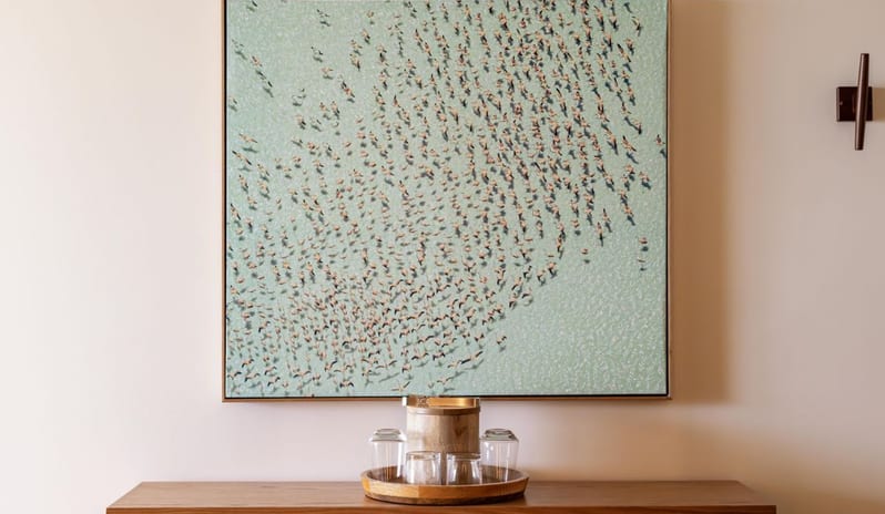 Two Bedroom Ocean View Suite, Top floor, Balcony Wooden hotel console table with a tray of drinking glasses, an ice bucket, and wall art at Salterra, A Luxury Collection Resort & Spa, South Caicos by Kenwood Travel