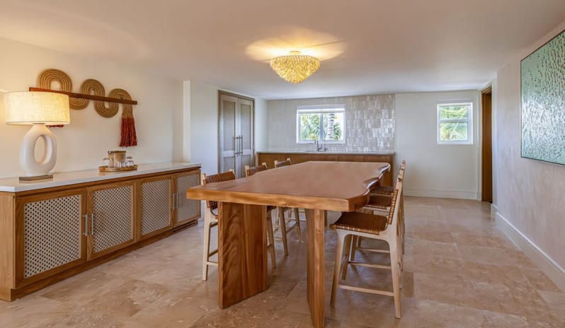 Two Bedroom Ocean View Suite Lanai Patio dining room with a natural wood dining table, woven high chairs, and wet bar at Salterra, A Luxury Collection Resort & Spa, South Caicos by Kenwood Travel