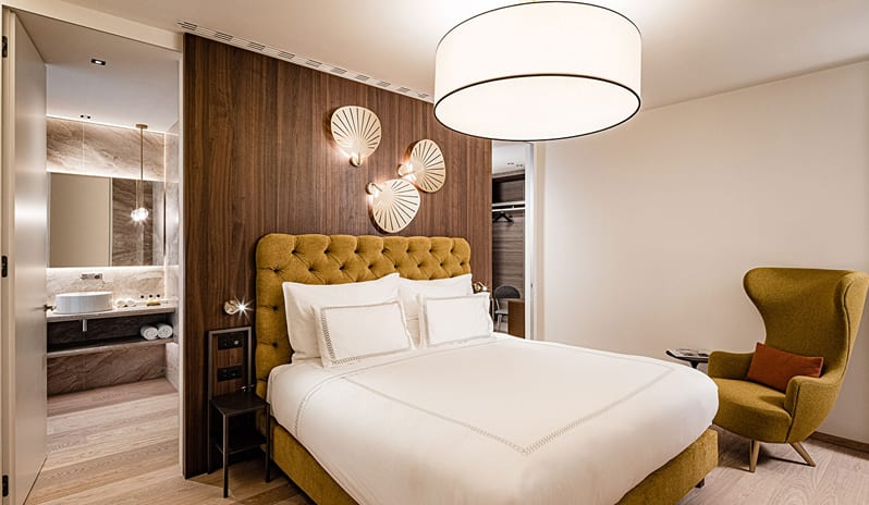 Iconic Aria Penthouse Suite Mustard yellow upholstered bed and modern interior decor at ARIA Retreat & SPA by Kenwood Travel
