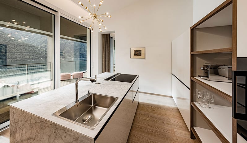 Iconic Aria Penthouse Suite Sleek kitchen island with marble countertops and scenic lake views at ARIA Retreat & SPA by Kenwood Travel