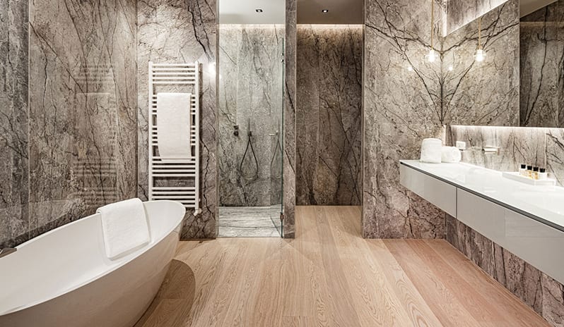 Lake View Loggia Suite bathroom with a white oval soaking tub, glass walk-in shower enclosure, heated towel rack, and floating vanity at ARIA Retreat & SPA by Kenwood Travel