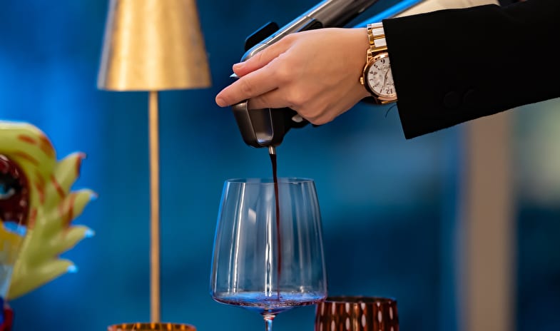 La Masseria Restaurant Pouring red wine into a glass with a wine preservation system at ARIA Retreat & SPA by Kenwood Travel