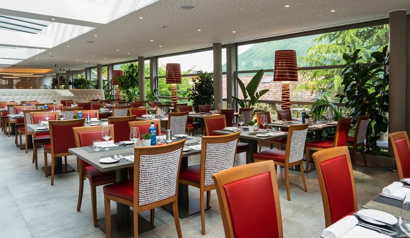 La Veranda & San Marco Restaurant Bright restaurant dining room with set tables and glass walls at ARIA Retreat & SPA by Kenwood Travel