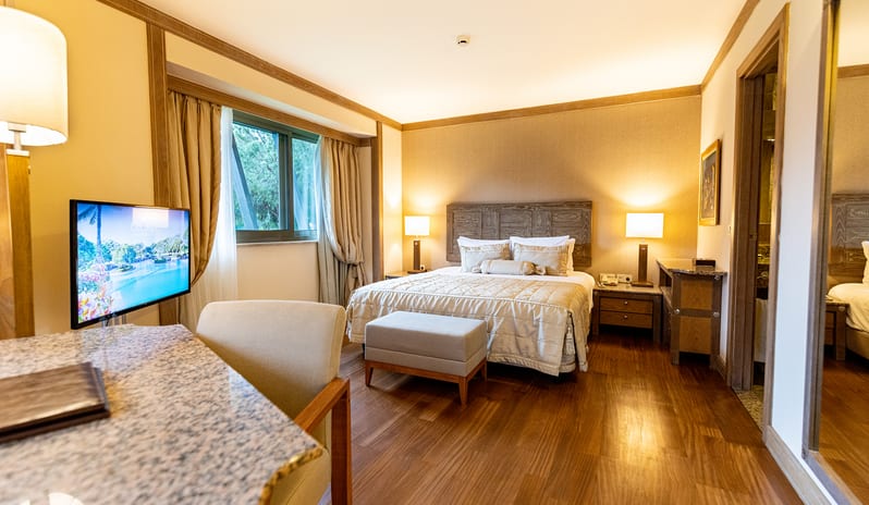 Select Villa king bed, wooden flooring, and a marble desk at Gloria Verde by Kenwood Travel