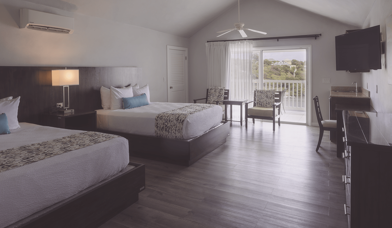 Waterfront Suite with vaulted ceilings and private balcony looking out to the water at The Verandah Antigua by Kenwood Travel