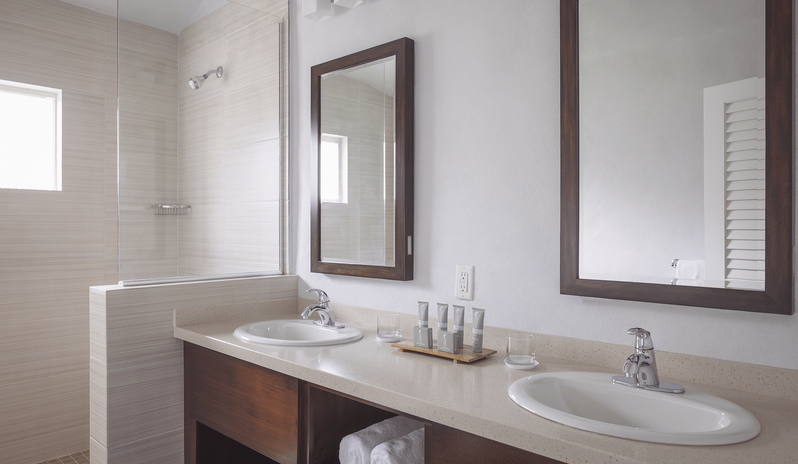 Waterfront Suite bathroom featuring a double sink vanity and walk-in shower at The Verandah Antigua by Kenwood Travel