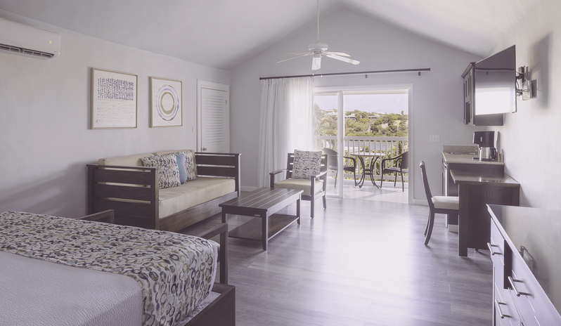 Water View Suite room with living area and private balcony overlooking a water view at The Verandah Antigua by Kenwood Travel